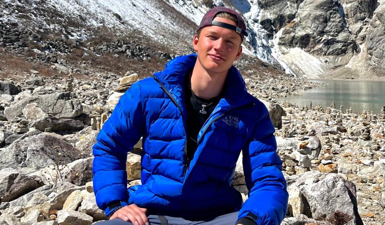 Erik Leegaard sitter smilende på tur i fjellet