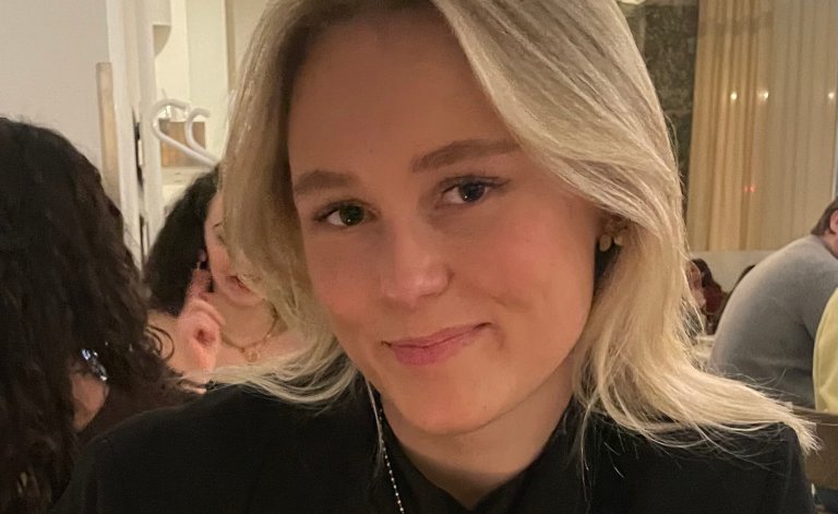 Portrettbilde av Pauline iført en svart genser og langt hår