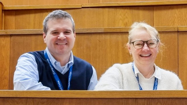 James Hathaway og Gry Espedal sitter ved siden av hverandre og smiler til kamera