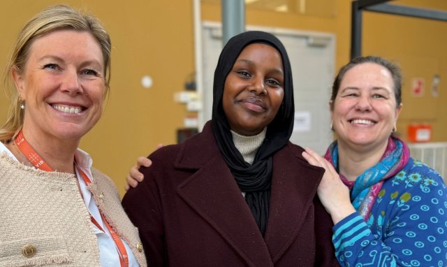 Student står sammen med to lærere