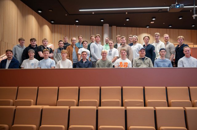 31 mannlige sykepleierstudenter står samlet i et auditorium