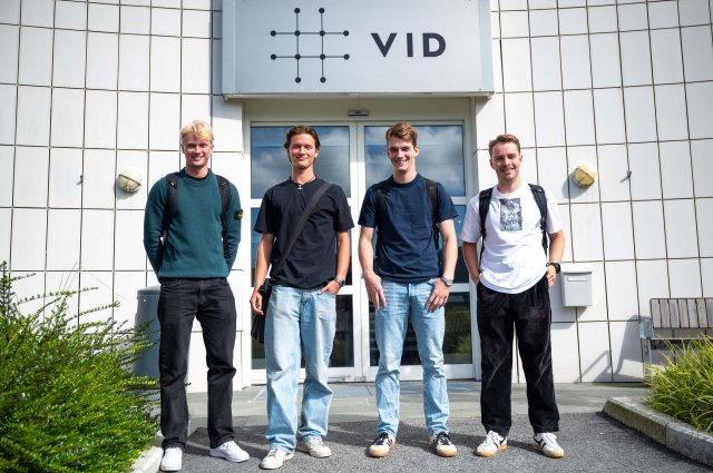 Fire studenter står på rekke ute på campus Bergen