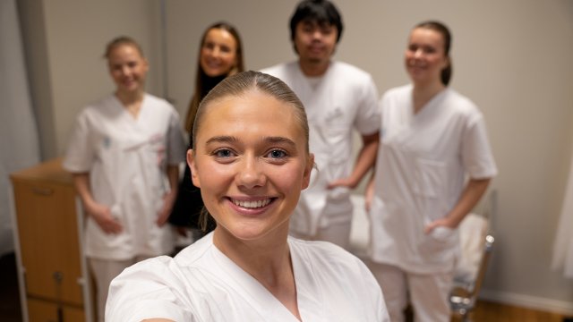 bilde av fem VID-studenter. Fire er i uniform. Den ene står foran med de andre i bakgrunnen. 