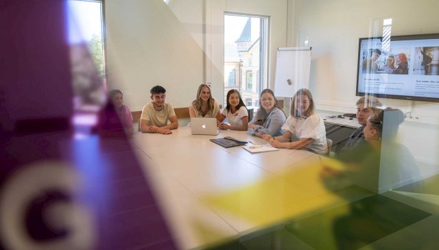 Studenter sitter rundt et bord