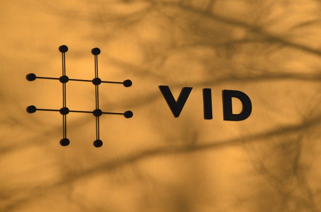 VID logo på gul vegg