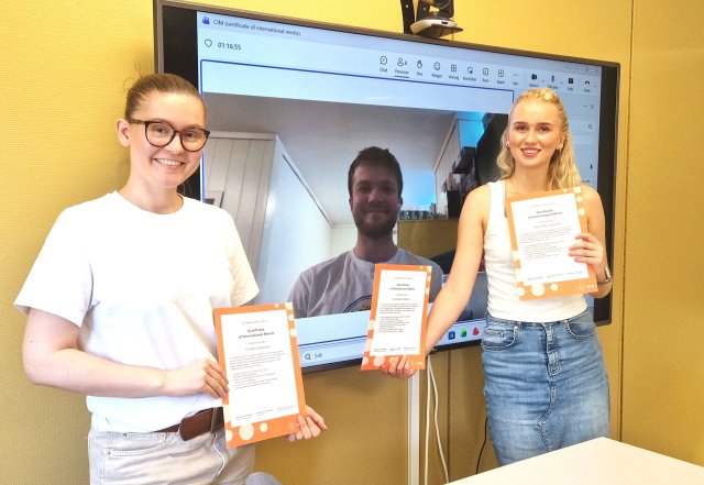 Tre studenter som holder et CIM-sertifikat hver
