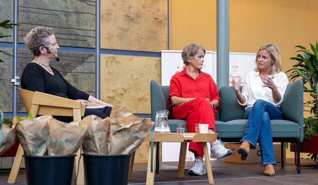 de tre sitter på scenen i atriet ved VID