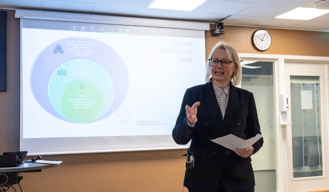 Kvinne foran powerpoint-presentasjon