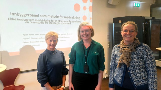 bilde av de tre stående foran powerpoint der det står "innbyggerpanel som metode for medvirkning"