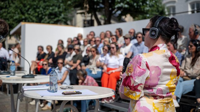Person i front med mange i publikum