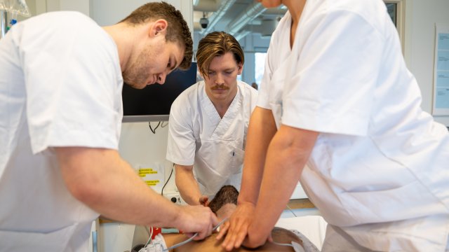 Tre sykepleierstudenter gjør hjerte og lungeredning på en mann