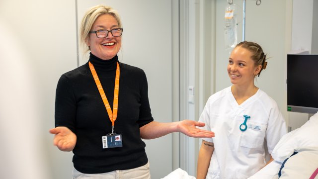 Dame med briller snakker med sykepleierstudenter