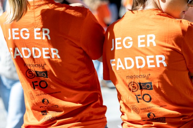 Ryggen på en t-skjorte hvor det står "jeg er fadder"