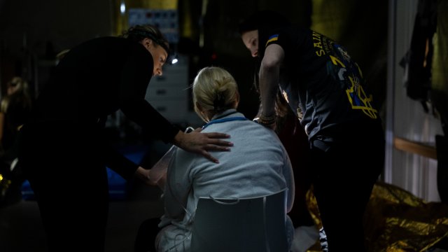 To mennesker hjelper en person i morgenkåpe under en simulering