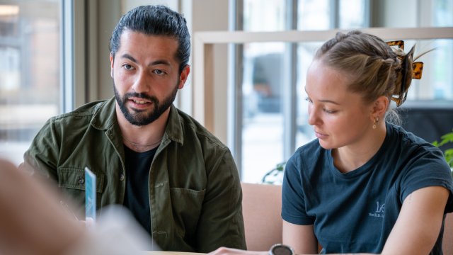 En jente og en gutt sitter ved en pult og studerer psykologi