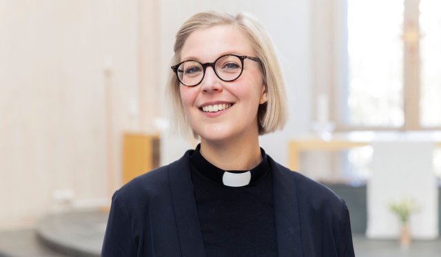 Dame med prestekjole foran et alter