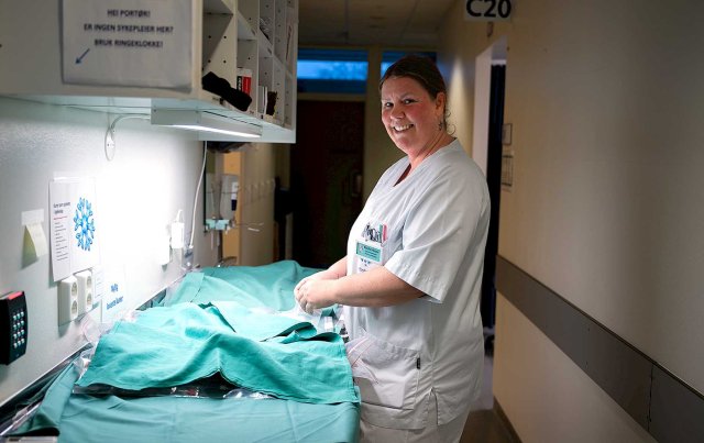 Sykepleier står foran en arbeidsbenk