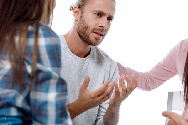 En mann holder hendene foran seg og er fortvilet