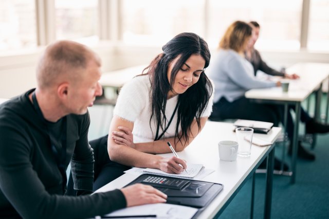 Studenter ved skrivebord samarbeider