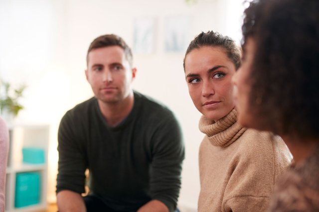 En gruppe mennesker sitter i ring og har en samtale.