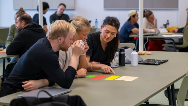 Studenter som diskuterer en oppgave