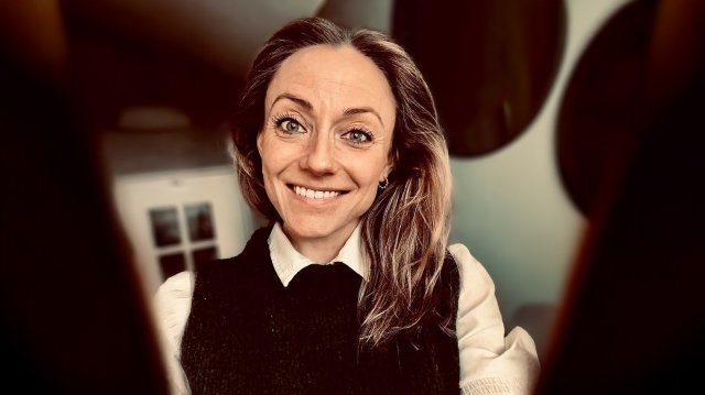 Ung smilende dame ser i kamera