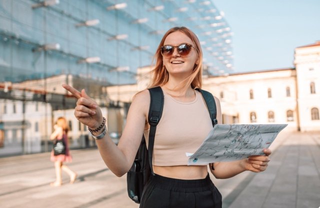 Tre studenter står ute og smiler