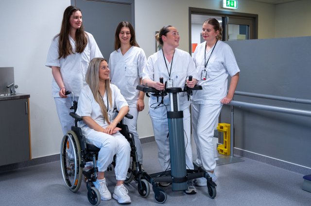 Fem studenter i uniform snakker sammen
