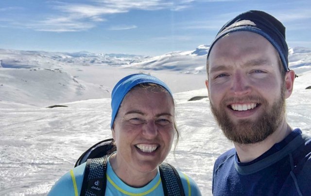 En mann og en kvinne poserer for kamera på fjellet